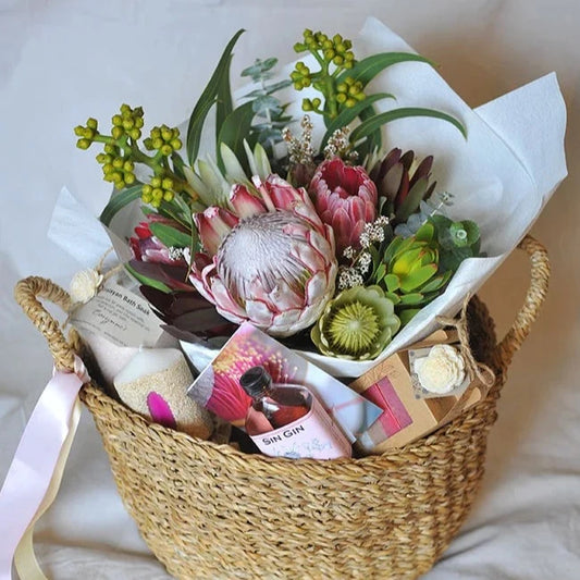 gift basket containing  Fair Trade basket from Urban Soul Living Freo Florist flowers Corrynne's four pack of deluxe soaps Corrynnes's Himalayan Pink Bath Salt Perth Pink Sin Gin Agate Sand Candle Neil Wallace Botanical Greeting Card